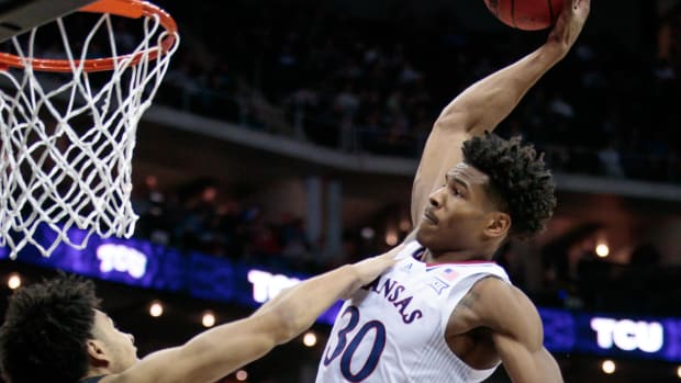 Mar 11, 2022; Kansas City, MO, USA; Kansas Jayhawks guard Ochai Agbaji (30) goes up to dunk over TCU Horned Frogs guard Micah Peavy (0) during the second half at T-Mobile Center. Mandatory Credit: William Purnell-USA TODAY Sports